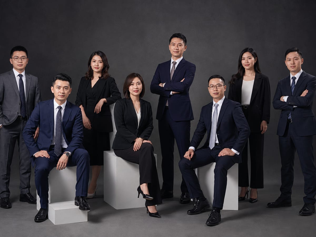 深灰底色棚拍企业团队合影,展示轮廓光与主辅光配合下的人物边界分离效果